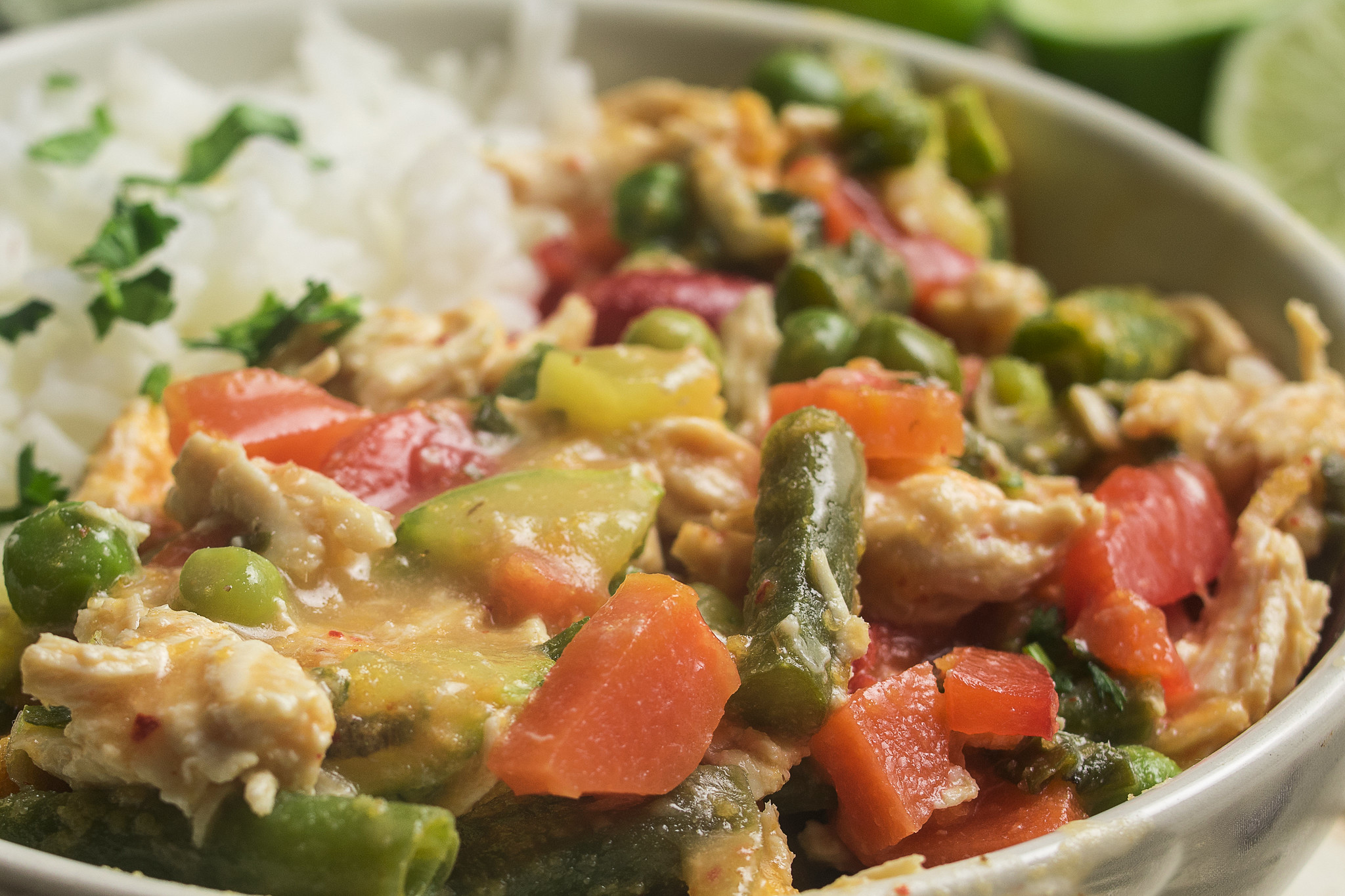 Close-up of Thai-inspired chicken curry with mixed vegetables and jasmine rice.